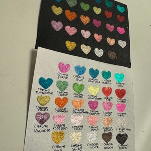 Puede incluir: Una tabla que muestra 25 colores diferentes de purpurina cromada en forma de coraz&oacute;n. Los colores est&aacute;n etiquetados con el nombre del color, como "Chrome P&uacute;rpura", "Chrome Azul", "Chrome Azul Claro", "Chrome Esmeralda", "Chrome Teal", "Chrome Turquesa", "Chrome Bosque", "Chrome Verde", "Chrome Verde Claro", "Chrome Rojo", "Chrome Marr&oacute;n", "Chrome Amarillos", "Chrome Naranja", "Chrome Naranja Claro", "Chrome Berenjena", "Chrome Rosa", "Chrome Rosa", "Chrome Lavanda", "Chrome Oro Rosa", "Chrome Lila", "Chrome Melocot&oacute;n", "Chrome Bronce", "Chrome Holo Plomo", "Chrome Oro", "Chrome Beige", "Chrome Plata", "Chrome Marr&oacute;n" y "Chrome Negro".