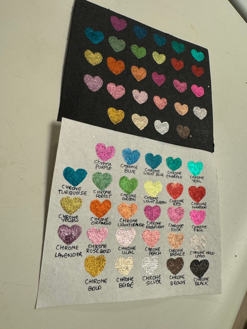 Puede incluir: Una tabla que muestra 25 colores diferentes de purpurina cromada en forma de coraz&oacute;n. Los colores est&aacute;n etiquetados con el nombre del color, como "Chrome P&uacute;rpura", "Chrome Azul", "Chrome Azul Claro", "Chrome Esmeralda", "Chrome Teal", "Chrome Turquesa", "Chrome Bosque", "Chrome Verde", "Chrome Verde Claro", "Chrome Rojo", "Chrome Marr&oacute;n", "Chrome Amarillos", "Chrome Naranja", "Chrome Naranja Claro", "Chrome Berenjena", "Chrome Rosa", "Chrome Rosa", "Chrome Lavanda", "Chrome Oro Rosa", "Chrome Lila", "Chrome Melocot&oacute;n", "Chrome Bronce", "Chrome Holo Plomo", "Chrome Oro", "Chrome Beige", "Chrome Plata", "Chrome Marr&oacute;n" y "Chrome Negro".