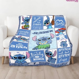 May include: A blue and white fleece blanket with a patchwork design featuring Stitch from Lilo & Stitch. The blanket has images of Stitch in various poses, including playing the ukulele, wearing a flower lei, and holding a surfboard. The blanket also includes the text "Ohana means family", "Family is everything", and "My name is Stitch".
