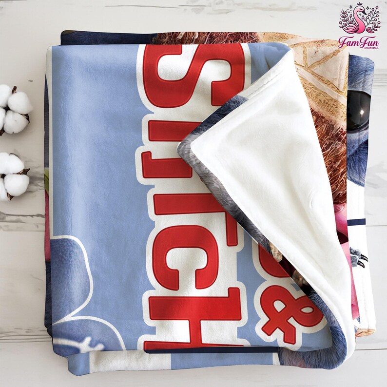 A folded blanket with the word "Sitch" printed on it, along with a cat image.