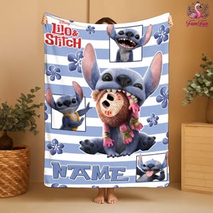A person is holding a blanket featuring the character Lilo & Stitch from the Disney movie. The blanket has a design with Lilo and Stitch in various poses, as well as a name tag.