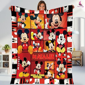 May include: A red, black, and white fleece blanket with a collage of Mickey Mouse images. The blanket has the name "NATALIE" printed in white letters and the word "MICKEY" printed vertically in white letters.