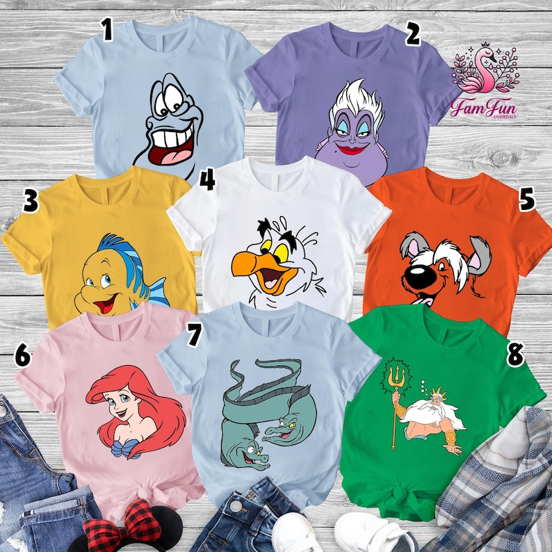 May include: A collection of eight short-sleeved t-shirts in various colors, each featuring a cartoon character from a popular animated film. The shirts are light blue, purple, yellow, white, orange, pink, light blue, and green. The characters include a smiling fish, a sea witch, and a king.