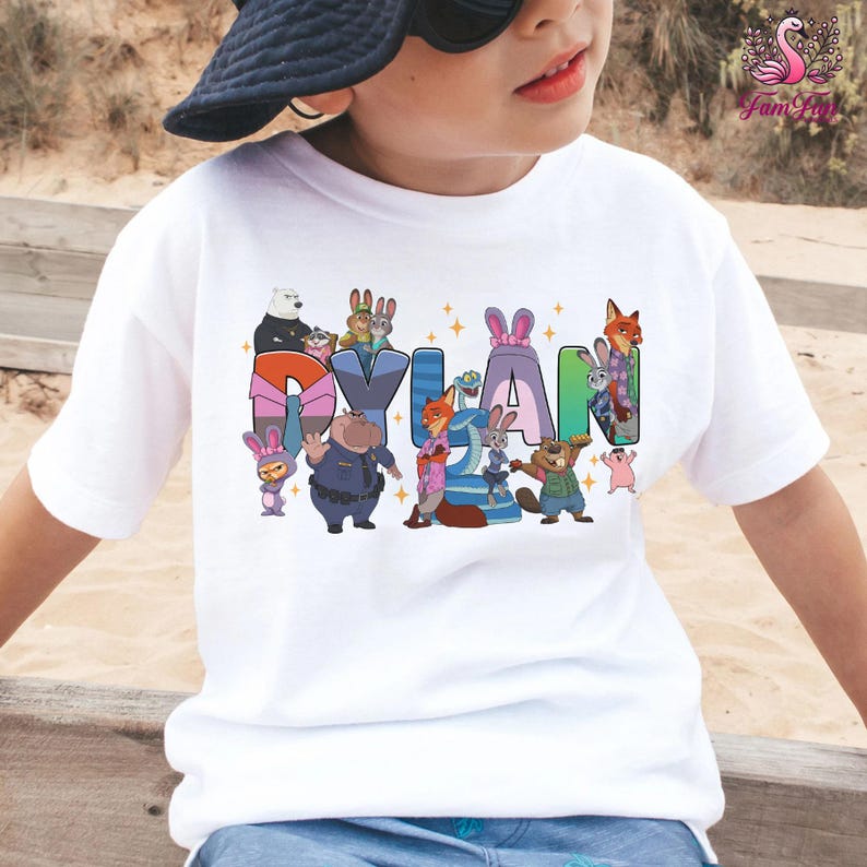 A child wearing a white t-shirt with a colorful graphic design featuring cartoon characters and the name "Dylan".