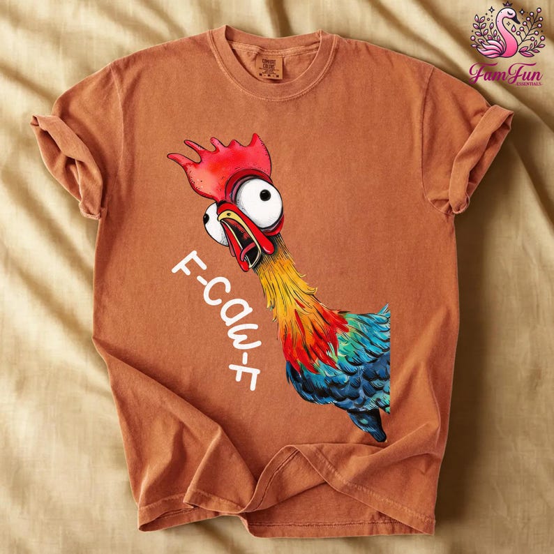 a brown t-shirt with a colorful illustration of a rooster and the text "F-COW" printed on it.