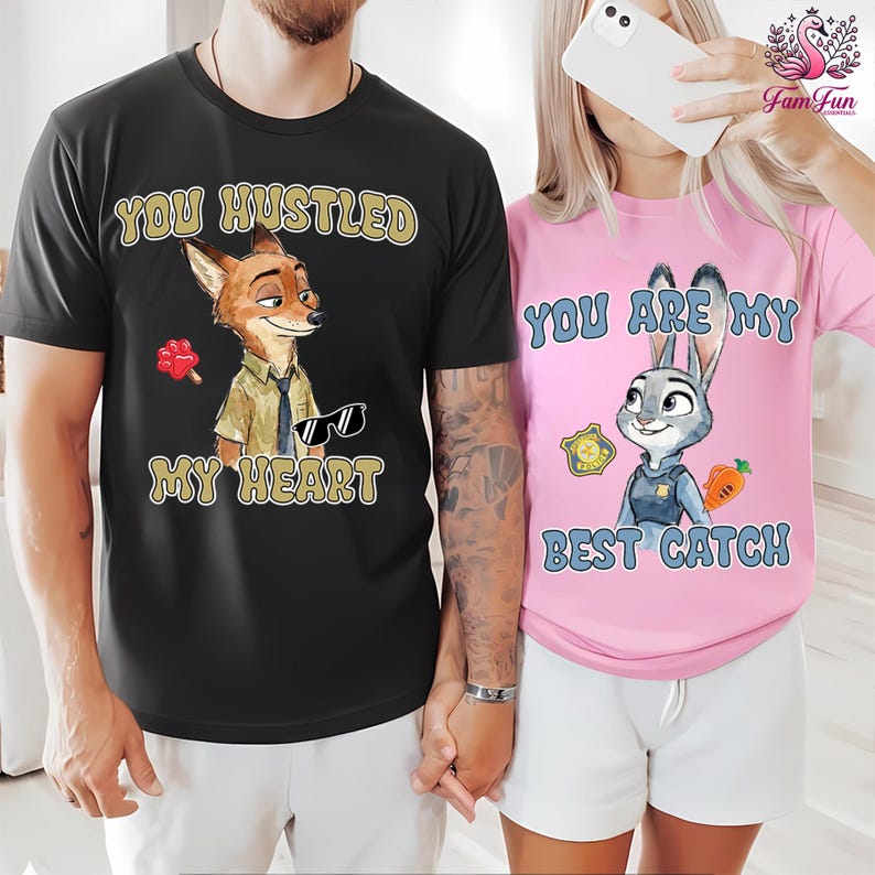 A man and a woman are standing together, both wearing t-shirts with cartoon animal characters and text.