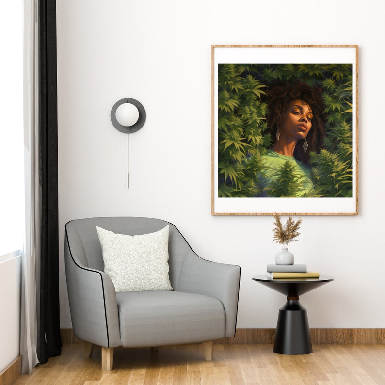 Op de afbeelding: Een ingelijste print van een vrouw met lang donker haar die in een veld met groene planten ligt. De vrouw draagt een groen shirt en heeft een gouden oorring in elk oor. De print is ingelijst in een licht houten lijst.