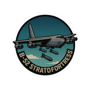 May include: A sticker featuring a gray B-52 Stratofortress bomber aircraft dropping bombs. The aircraft is set against a teal and blue sky background, with the words "B-52 STRATOFORTRESS" in white text around the edge of the circle.