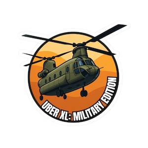 Op de afbeelding: Een sticker met een cartoon illustratie van een militaire helikopter in vlucht. De helikopter is olijfgroen, tegen een oranje en gele achtergrond. De tekst "UBER XL: MILITARY EDITION" staat op de sticker.