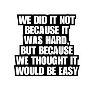 May include: A white sticker with black text. The text reads: "WE DID IT NOT BECAUSE IT WAS HARD, BUT BECAUSE WE THOUGHT IT WOULD BE EASY."