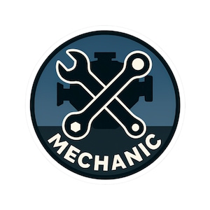 May include: A round sticker with a blue and white design. The sticker features crossed wrenches and the word "MECHANIC" in white text. The background is a dark blue circle with a silhouette of an engine.