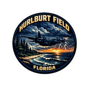 May include: A circular sticker featuring a detailed illustration of a military aircraft flying over a beach scene at sunset. The design includes text that reads "HURLBURT FIELD FLORIDA" in a navy blue and gold color scheme, with lightning bolts.