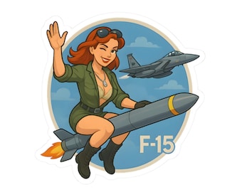 Könnte beinhalten: Ein Aufkleber mit einer Cartoon-Illustration einer Frau, die auf einer Rakete reitet, mit einem F-15-Jet im Hintergrund. Die Frau trägt ein grünes Outfit und winkt. Der Aufkleber hat einen blauen Hintergrund mit dem Text "F-15".