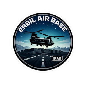 May include: A circular sticker featuring a black helicopter over a runway, with the text "ERBIL AIR BASE" in a circular design. The background shows a night sky, buildings, and mountains. The word "IRAQ" is also present.
