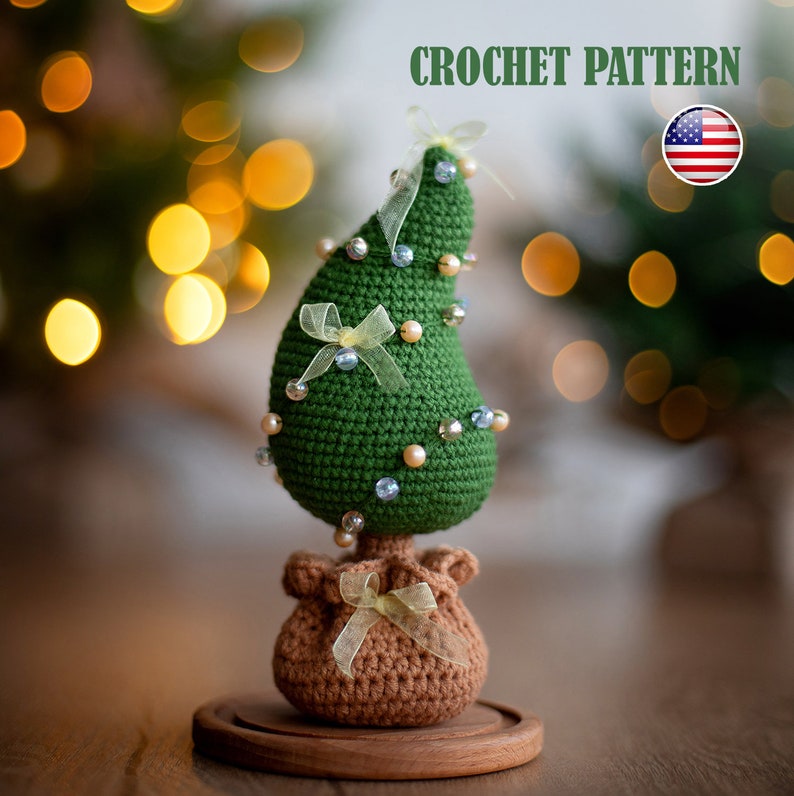 May include: Crocheted Christmas tree ornament with a brown crocheted base and a wooden stand. The tree is decorated with blue and white beads and yellow ribbons.