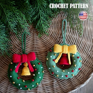 May include: Two handmade crochet Christmas wreath decorations. Each wreath is green with red and gold bead accents, a bow, and a bell. The text "CROCHET PATTERN" is at the top. An American flag is in the upper right corner.