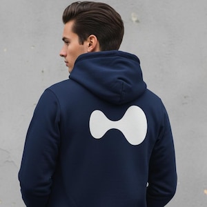 May include: Navy blue hoodie with a white abstract design on the back. The hoodie features a hood and a front pocket. The model is wearing the hoodie, and the background is a gray wall.