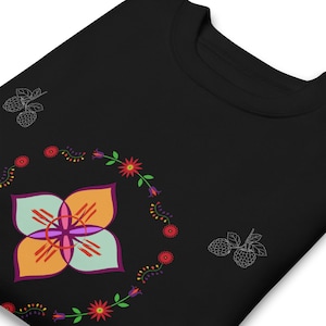 May include: Black sweatshirt with a colorful floral design. The design includes a large, multi-colored flower in the center, surrounded by a floral wreath. Two white outline drawings of raspberries are on the sweatshirt.