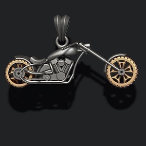 May include: A silver motorcycle pendant with gold-colored wheels. The motorcycle has a detailed design and is a great addition to any jewelry collection.