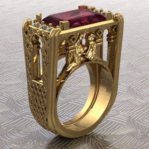 Puede incluir: Un anillo dorado con una gran gema rectangular de color rojo intenso. El anillo tiene un diseño arquitectónico ornamentado con filigranas detalladas y pequeñas piedras de acento. El diseño del anillo incluye figuras y elementos decorativos.