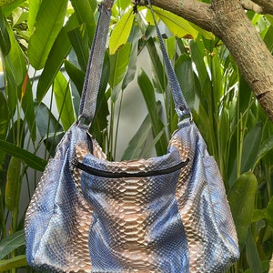 May include: A blue and brown snakeskin shoulder bag with a zip closure.