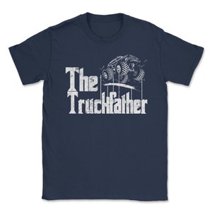 Op de afbeelding: Marineblauw T-shirt met de tekst "The Truckfather" in een verweerde witte letter. Een afbeelding van een monstertruck staat boven de tekst. Het shirt heeft een ronde hals en korte mouwen.