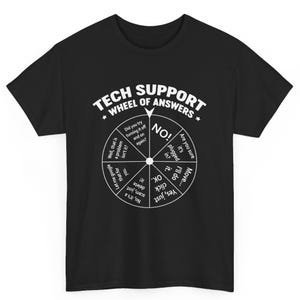 Pode incluir: Camiseta preta com um gráfico branco de um jogo estilo roleta da fortuna com o texto "Tech Support Wheel of Answers". A roda tem frases como "Você tentou desligar e ligar novamente?" e "Deixe-me pesquisar isso no Google para você".