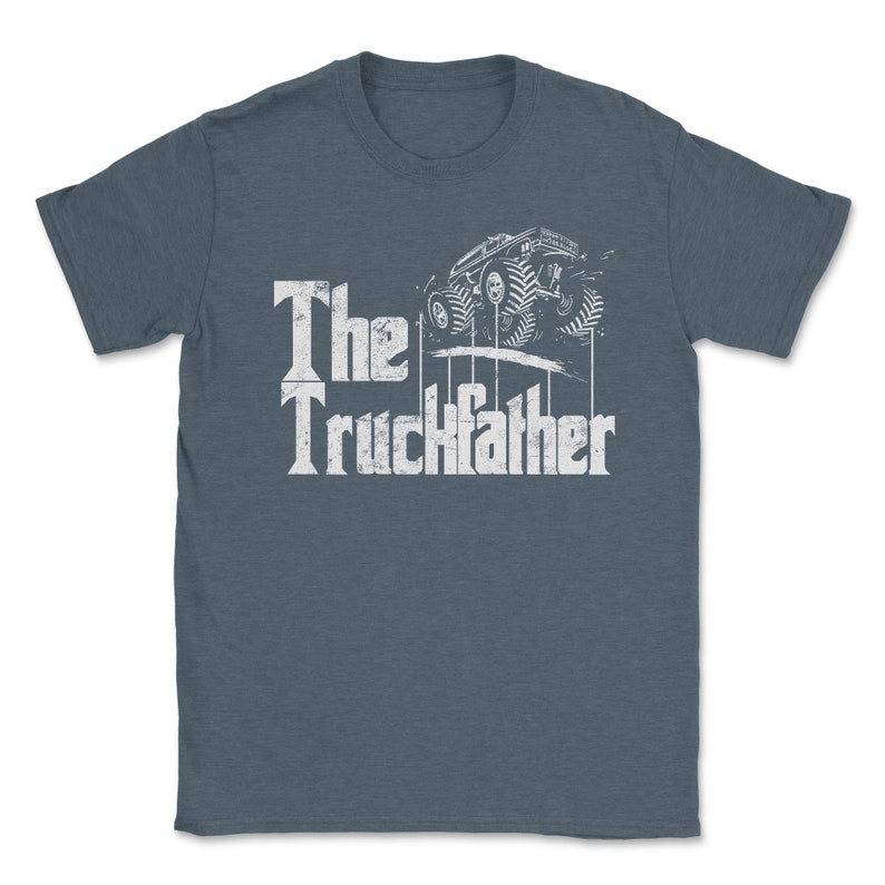 Op de afbeelding: Blauw t-shirt met de witte tekst "The Truckfather" en een afbeelding van een monstertruck. Het ontwerp heeft een vintage uitstraling.