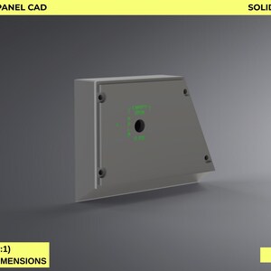 Könnte beinhalten: A-10C Canopy Open Panel CAD in Grau, mit dem Text "SOLIDWORKS + CNC READY" und "REAL SCALE (1:1) BASED ON ORIGINAL DIMENSIONS". Das Design zeigt eine rechteckige Box mit einer schrägen Seite und einer kreisförmigen Öffnung.