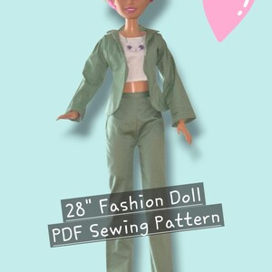 May include: A 28-inch fashion doll wearing a sage green blazer and matching trousers over a white crop top with a beaded necklace. The doll has blonde hair and pink shoes. Text on the image reads 28" Fashion Doll PDF Sewing Pattern.