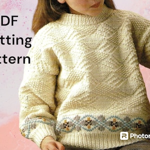 May include: PDF knitting pattern for a cream coloured sweater with a geometric pattern and a blue and brown trim.