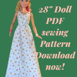 Puede incluir: Una muñeca con un vestido azul claro con estampado de conchas marinas. El texto sobre fondo verde dice "28" Doll PDF sewing Pattern Download now!". La muñeca lleva un lazo rosa, collar y pulseras. El vestido es para una muñeca de 71 cm.