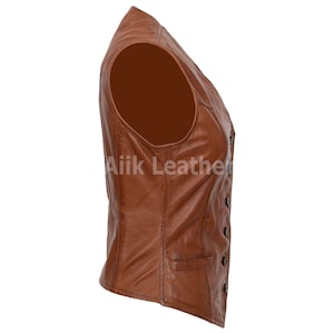 Op de afbeelding: Een bruin leren vest met knoopsluiting. Het vest heeft een zak aan de voorkant en is mouwloos.