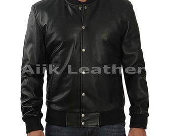 May include: Black leather bomber jacket with a ribbed collar, cuffs, and hem. The jacket has a button-up front and the text "Airk Leather" is visible. A classic outerwear piece.