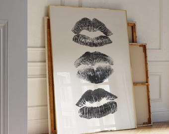 May include: A framed print with three black and white lip prints on a white background. The frame is gold.