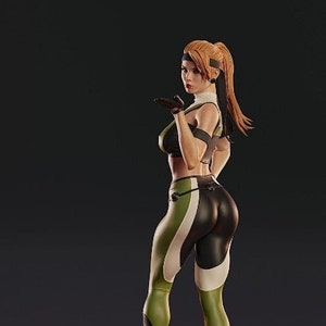May include: A detailed statue of a female figure in a fighting pose, wearing a black and green outfit with white accents. The figure is standing on a detailed, ornate base with a fiery red glow. The statue has a dynamic pose and realistic details.