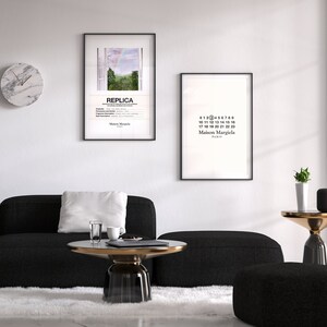 May include: A living room interior with a black sectional sofa, a white rug, a round glass coffee table with a gold metal base, a black and white clock, and two framed prints on the wall. The prints feature a landscape scene with a rainbow and the text "REPLICA" and a black and white print with the text "Maison Margiela" and numbers 0-22.