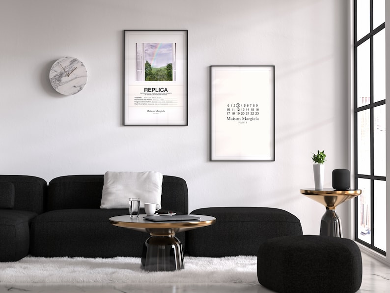 May include: A living room interior with a black sectional sofa, a white rug, a round glass coffee table with a gold metal base, a black and white clock, and two framed prints on the wall. The prints feature a landscape scene with a rainbow and the text "REPLICA" and a black and white print with the text "Maison Margiela" and numbers 0-22.