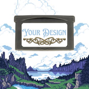 Puede incluir: Un cartucho gris de Game Boy Advance con una etiqueta blanca con el texto "YOUR DESIGN" en azul claro y un elemento decorativo dorado. El fondo es un paisaje pixelado con montañas, agua y cielo.