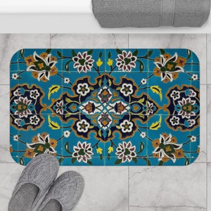 May include: A blue bath mat with a colorful geometric pattern featuring floral designs. The mat has a textured surface and is made of durable material.
