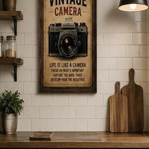 Peut inclure: Une affiche encadrée rectangulaire représentant un appareil photo vintage. Le texte indique : The VINTAGE CAMERA, LIFE IS LIKE A CAMERA, FOCUS ON WHAT'S IMPORTANT, CAPTURE THE GOOD TIMES, DEVELOP FROM THE NEGATIVES. L'impression présente un ton sépia.