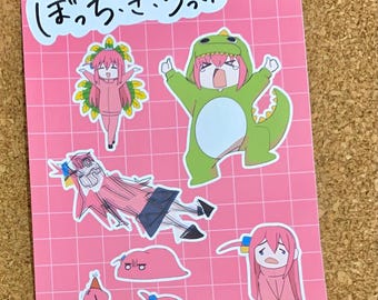 May include: A set of pink and green stickers featuring a cartoon character with different expressions. The stickers have Japanese text that says "まっち・ごっこ!"