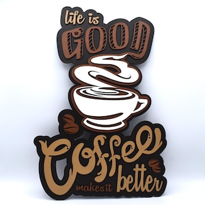 May include: A layered wooden sign with the words "life is good" and "Coffee makes it better." The sign features a white coffee cup with steam and coffee beans. The sign is in shades of brown, black, and white.