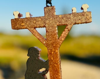 May include: A brown and gold glitter resin ornament of a lineman climbing a power pole. The lineman is black and the power pole has white insulators.