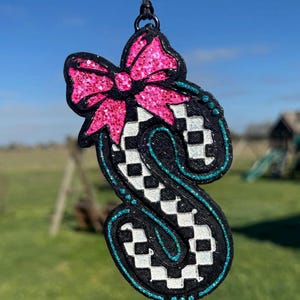 May include: A handmade wooden sign with the text "Welcome" in a playful font. The sign is painted white with a distressed finish, and features a decorative floral design in shades of pink and green. It is designed for indoor or outdoor use.