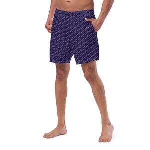 Puede incluir: Un par de pantalones cortos deportivos de color azul oscuro con un estampado de palmeras blancas y azul claro. Los pantalones cortos tienen una cintura elástica y un cordón.