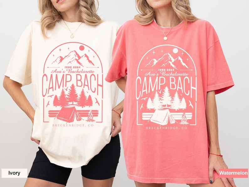 May include: Two t-shirts with a camping theme design. The design features a mountain range, trees, a tent, and a campfire. The text on the shirts reads "JUNE 2024 Ava's Bachelorette CAMP BACH BRECKENRIDGE, CO". The shirts are available in ivory and watermelon.