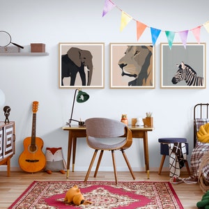 May include: A child's bedroom with a white wall, a wooden desk, a chair, a bed, and three framed animal prints. The prints feature a lion, an elephant, and a zebra. The room is decorated with a colorful garland and a rug.