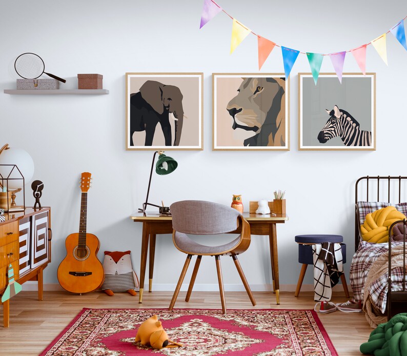 May include: A child's bedroom with a white wall, a wooden desk, a chair, a bed, and three framed animal prints. The prints feature a lion, an elephant, and a zebra. The room is decorated with a colorful garland and a rug.