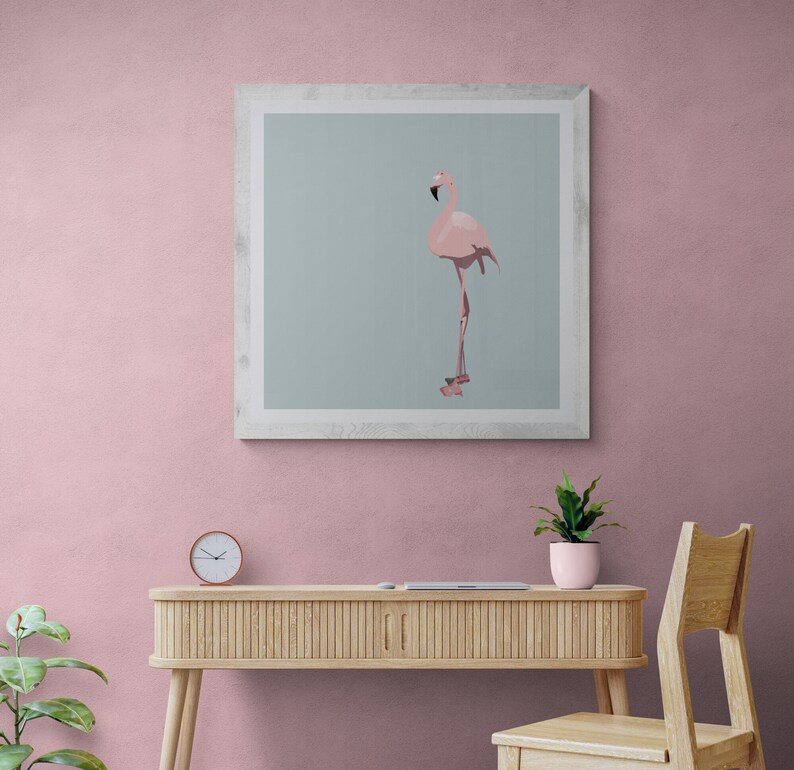 May include: A framed print of a pink flamingo standing on one leg against a light blue background. The frame is white and has a simple design.
